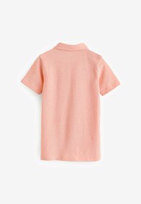 Camisa polo en rosa suave, de manga corta, con collar clásico, tejido texturizado, vista trasera. Diseño simple sin patrones visibles ni hardware.