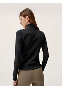 Black long-sleeve top with a high collar, featuring textured vertical stripes, fitted design, and a smooth fabric finish.