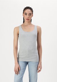 Graues Baumwoll-Tanktop mit U-Ausschnitt, breiten Trägern und taillierter Passform. Kombiniert mit hellblauen, verwaschenen Jeans.