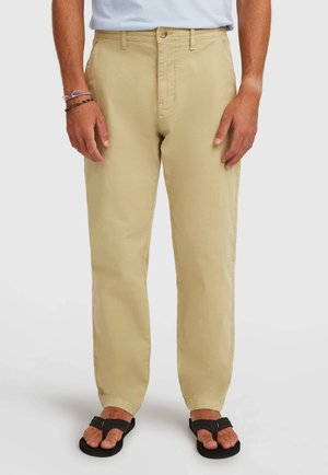 Kaki chinos lavet af bomuld, med lige ben, knaplukning og flade lommer, stylet med sorte sandaler og en lyseblå skjorte.