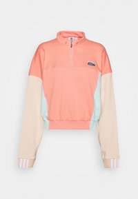 Kortärmad tröja med kvart-zip, med korall-, mint- och beige färgblock, samt en liten svart logotyp på bröstet.