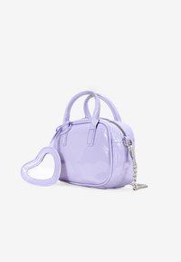 Bolso de charol púrpura con forma redondeada, doble asa y un charm de espejo en forma de corazón. Cuenta con un cierre de cremallera y detalle de cadena plateada.