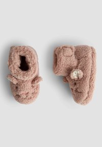 Mjuka rosa tofflor i boot-stil, tillverkade av fluffigt material, med kaninöron, en stickad ansiktsdetalj och en dekorativ knapp på sidan.