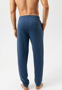 Donkerblauwe joggingsbroek met elastische tailleband en een enkele achterzak, gemaakt van zacht stof, met een rechte pijp en een minimalistisch ontwerp.