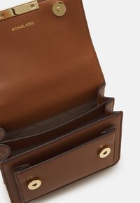 Bruine leren portemonnee van Michael Kors, opengevouwen met meerdere compartimenten en vergulde drukknoopsluitingen.