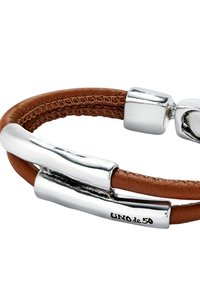 Pulsera de cuero marrón con detalles de metal plateado y un acabado pulido. Detalles notables incluyen un cierre único y grabado de la marca.