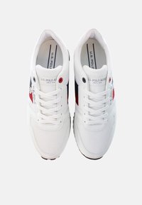 Scarpe da ginnastica bianche in materiali mesh e sintetici. Presentano accenti rossi e blu navy, lacci rotondi e un logo laterale. Design classico delle sneaker.