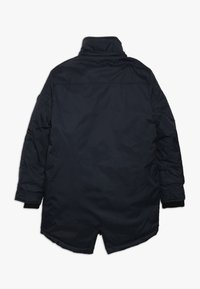 Parka azul marino aislante con un cuello alto, puños elásticos y un dobladillo ligeramente curvado. Tejido suave, diseño minimalista.