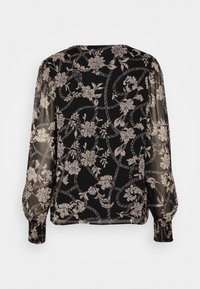Blusa nera trasparente con motivo floreale in crema. Presenta maniche lunghe a sbuffo e polsini arricciati, con scollatura rotonda e una texture morbida.