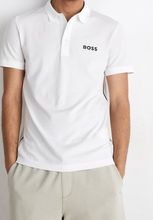 Hvid poloshirt med ribkantet krave, korte ærmer og et sort "BOSS"-logo på brystet. Slim fit med sideaccenter.
