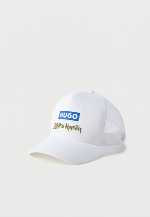 Hvit baseballcaps med buet brem, med en blå "HUGO"-logo og "Jujutsu Kaisen" i grønn tekst. Netting på sidene for god pusteevne.