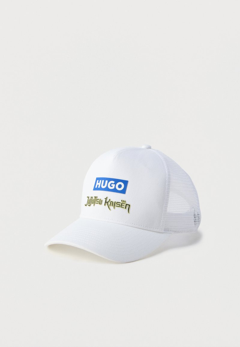 Gorra de béisbol blanca con visera curva, presenta un logo azul "HUGO" y el texto "Jujutsu Kaisen" en verde. Laterales de malla para mayor transpirabilidad.