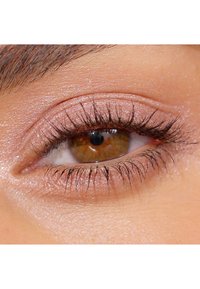 Gros plan sur un œil marron avec des cils bien définis, un léger éclat sur la paupière et une texture de peau lisse entourant l'œil.