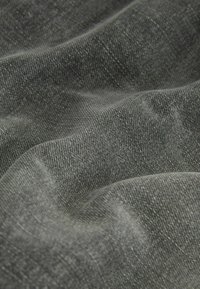 Dark gray denim fabric with a soft texture featuring subtle fading and a slightly rugged appearance, showcasing woven patterns and fibers.