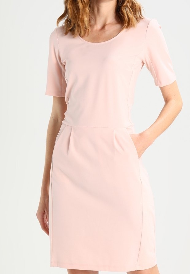 Vestido rosa claro con mangas cortas, escote redondo, dos bolsillos laterales, textura suave y diseño ajustado. Se pueden ver los detalles de costura.