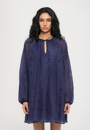 Navyblauwe chiffon jurk met een sleutelgat halslijn, lange ballonmouwen en geborduurde bloemendetails. Gladde, lichte textuur.