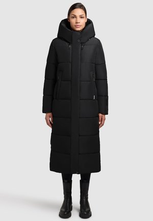 Sort pufferjakke med et langt, tætsiddende design, stor hætte og lynlåslommer foran. Glat tekstur med en mat finish og kviltet mønster.