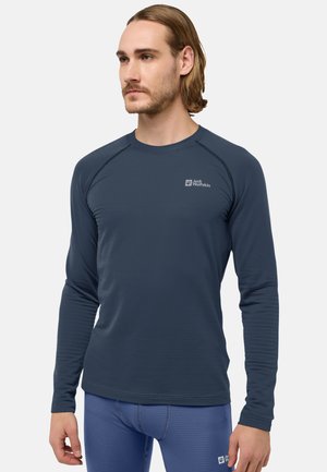 T-shirt de sport à manches longues en marine, en tissu texturé, avec un col rond et un logo subtil sur la poitrine. Coupe ajustée avec des manches raglan.