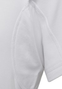 Lys hvid bomulds t-shirt i close-up, med ribbet tekstur ved kraven og glat stof med synlige syninger på ærmesømmene.