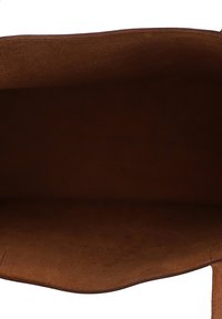Intérieur de sac en cuir marron vide vu de dessus avec une texture douce en daim et ouverture sur le dessus.