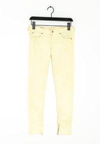 Vaqueros pitillo amarillos de mezclilla con cremallera en el tobillo, que cuentan con bolsillos frontales y cierre de botón. Diseñados para una silueta ajustada.
