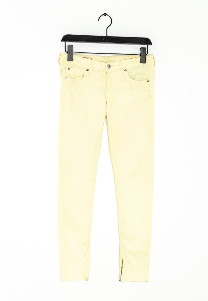 Vaqueros pitillo amarillos de mezclilla con cremallera en el tobillo, que cuentan con bolsillos frontales y cierre de botón. Diseñados para una silueta ajustada.