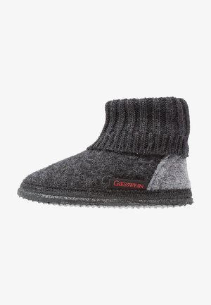 Chausson en laine gris avec un revers en tricot côtelé. Présente un design noir et gris, une pointe arrondie et une semelle texturée. Étiquette Giesswein visible.
