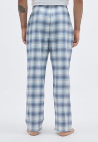Pantaloni de pijama în carouri albastre și albe, cu talie elastică, picioare drepte și textură moale a țesăturii, văzuți din spate.