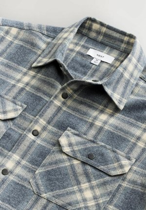 Flanellhemd mit einem blau- und cremefarbenen Karomuster, ausgestattet mit einem Kragen, zwei vorderen Taschen, schwarzen Knöpfen und einer weichen Textur. Markenlabel sichtbar.