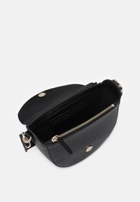 Černá kožená crossbody taška se zaobleným tvarem. Obsahuje zipové zapínání, hardwarové komponenty ve zlatém odstínu a více slotů na karty uvnitř.