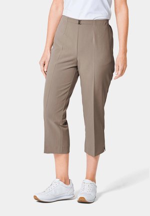Khaki capri-broeken met een gladde textuur, middenhoogte pasvorm, plooien aan de voorkant en splitten aan de zoom. Gecombineerd met witte sportieve schoenen.