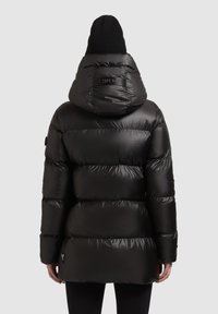 Fekete steppelt dzseki kapucnival, fényes felülettel, vízszintes varrott részekkel és logóval a háton.