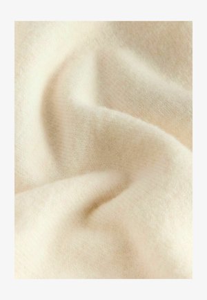 Pehmeast, kreemjat beezist kangast, millel on sile, kergelt tekstureeritud pind ja peen sära, esitades õrnad voldid ja voolava välimuse.