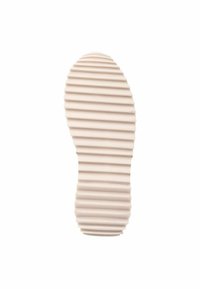 Semelle de chaussure beige clair avec des rainures verticales, forme arrondie et surface texturée pour une meilleure adhérence. Bords lisses et couleur uniforme sur toute la surface.