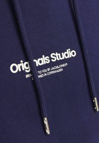 Felpa con cappuccio blu navy caratterizzata da un logo bianco "Originals Studio" e punte in metallo argentato sui cordini, realizzata in morbido cotone.