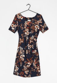 Robe bleu marine à manches courtes, imprimé floral en marron, blanc et rouge, avec un détail froncé à l'avant, suspendue sur un cintre noir.