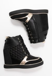 Svarta kilklacksneakers med quiltad struktur, glänsande gulddetaljer och en mix av material, inklusive slät och mönstrad tyg, med snörning.