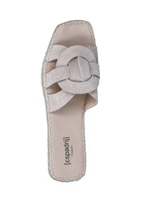Beige suede slide sandal with cross-woven straps and circular accent. Sole has stitched edging for added detail. Flat design for comfort.