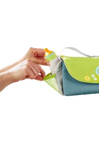 Diaper bag with green and blue fabric, mesh side pocket holding a colorful baby bottle with a yellow cap, lightweight design, and shoulder strap.