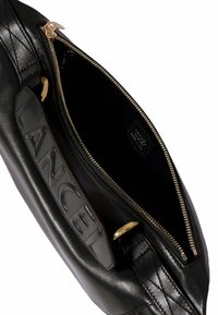 Μαύρη δερμάτινη τσάντα με καπιτονέ σχέδιο, που διαθέτει χρυσό φερμουάρ και υφή λογότυπου στην μπροστινή πλευρά. Το εσωτερικό είναι επενδυμένο με μαύρο ύφασμα.