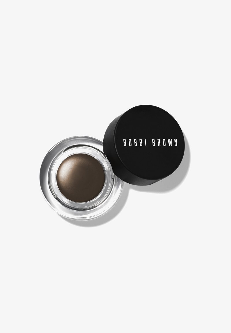 Bobbi Brown øyenbryns pomade i en klar beholder med svart lokk. Kremet, mørkebrun produkt med en jevn tekstur.
