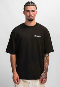 Schwarzes Baumwoll-T-Shirt mit weitem Schnitt, mit weißem "Dropsize"-Text auf der linken Brust, kurzen Ärmeln und glatter Textur.