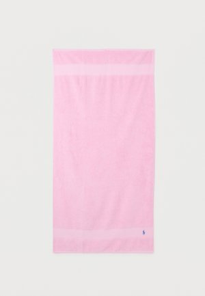 Serviette rectangulaire rose pâle avec une large bande horizontale près du haut et du bas, comportant un petit logo brodé bleu en bas à droite.