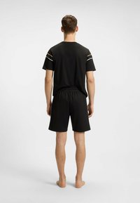 Zwart sportief shirt en short set, met korte mouwen en een elastische tailleband, met een minimalistisch ontwerp zonder zichtbare patronen of logo's.