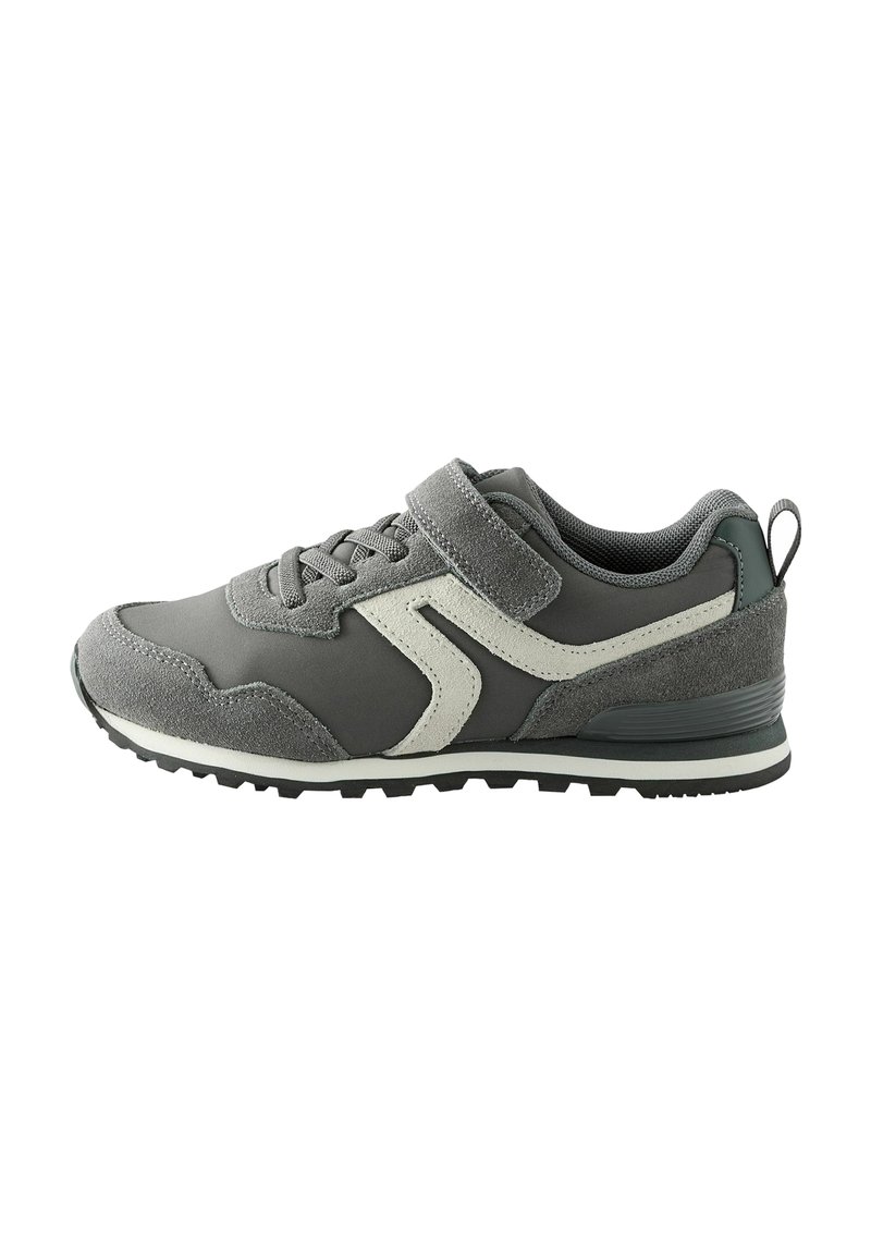 Gray athletic shoe with a suede and mesh upper, featuring a white accent design, lace closure, and a Velcro strap. Textured rubber sole.
