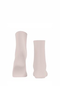 Jasnoróżowe skarpetki z prążkowanej tkaniny o miękkiej teksturze, sięgające do połowy łydki, o gładkim, bezszwowym wykończeniu.