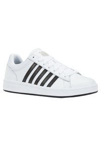 White sneaker with black stripes, made of synthetic material. Features a round toe, flat sole, and lace-up design with mesh accents.