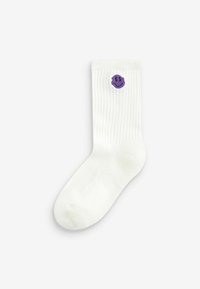 Calze bianche a coste con un piccolo sorriso ricamato di colore viola vicino alla caviglia. Texture liscia con un design classico.