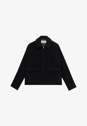 Giacca nera in lana con colletto a punta, zip frontale e due tasche applicate. Presenta maniche lunghe e una forma tailored e cropped.
