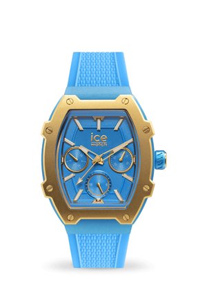 Orologio con cinturino in silicone blu e cassa in acciaio inox dorato, caratterizzato da un quadrante blu, tre sotto-quadranti e dettagli testurizzati sul cinturino.